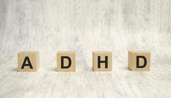 Concept of ADHD Attention Deficit Hyperactivity Disorder word on Wooden cube photo