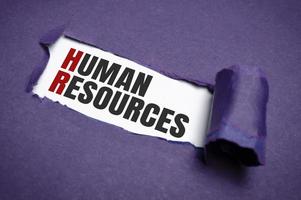 Torn purple paper on white surface with HUMAN RESOURCES word. Business concept photo