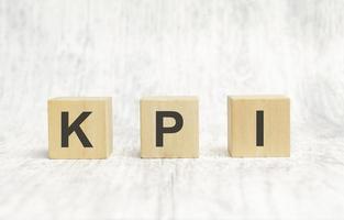 Cubes and dice with KPI Key Performance Indicator on wooden background photo