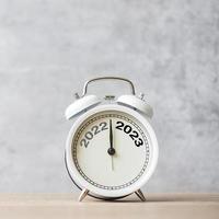 Happy New Year with vintage alarm clock and 2022 change to 2023 number. Merry Christmas, New Start, Resolution, countdown, Goals, Plan, Action and Mission Concept photo