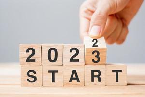 hand flipping block 2022 to 2023 START text on table. Resolution, strategy, goal, motivation, reboot, business and New Year holiday concepts photo