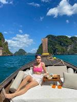 Woman tourist in private longtail boat trip to island with exotic food picnic, Krabi, Thailand. landmark, destination, Asia Travel, vacation, wanderlust and holiday concept photo