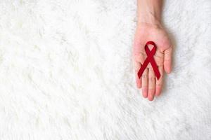 cinta roja burdeos para apoyar a las personas que viven y están enfermas. concepto de salud y sexo seguro. diciembre día mundial del sida y mes de concientización sobre el cáncer de mieloma múltiple foto