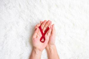 cinta roja burdeos para apoyar a las personas que viven y están enfermas. concepto de salud y sexo seguro. diciembre día mundial del sida y mes de concientización sobre el cáncer de mieloma múltiple foto