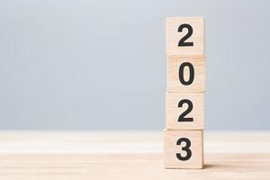 wooden cube block with 2023 text on table background. Resolution, plan, review, goal, start and New Year holiday concepts photo