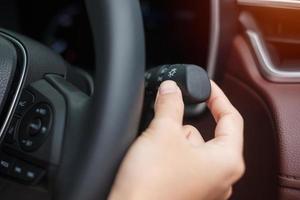 Encienda el interruptor de la luz con la mano dentro del automóvil. concepto de transporte de seguridad foto