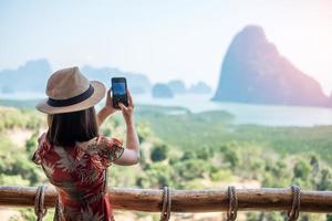 Happy traveler woman enjoy Phang Nga bay view point, alone Tourist relaxing at Samet Nang She, near Phuket in Southern Thailand. Southeast Asia travel, trip and summer vacation concept photo