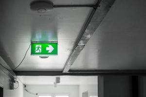 Fire Emergency exit sign on the wall background inside building. Safety concept photo