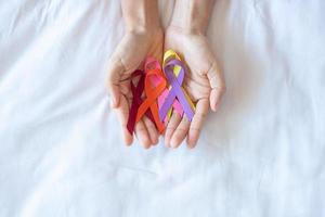 World cancer day. colorful awareness ribbons red, orange, purple, pink and yellow color for supporting people living and illness. Healthcare and medical concept photo