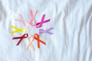 World cancer day. colorful awareness ribbons red, orange, purple, pink, peach and yellow color for supporting people living and illness. Healthcare and medical concept photo