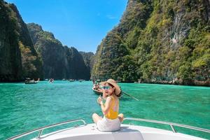 mujer turista en viaje en barco, viajero feliz relajándose en la laguna pileh en la isla phi phi, krabi, tailandia. punto de referencia exótico, concepto de viajes, vacaciones y vacaciones del sudeste asiático foto