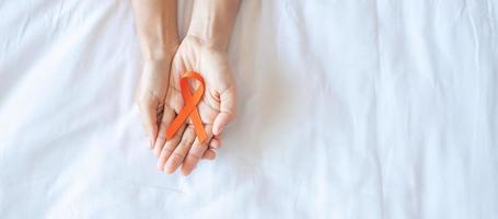 leucemia, día del cáncer de riñón, esclerosis múltiple mundial, crps, mes de concientización sobre autolesiones, cinta naranja para apoyar a las personas que viven y están enfermas. concepto de salud y día mundial del cáncer foto