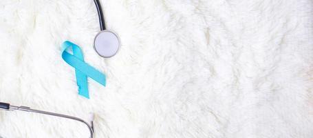 conciencia del cáncer de próstata de noviembre, cinta azul claro con estetoscopio para apoyar a las personas que viven y están enfermas. concepto del día de la diabetes, el hombre internacional y el día mundial del cáncer foto