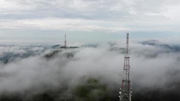 vista aérea duas torre de telecomunicações 4g, 5g na névoa da nuvem de neblina video