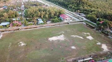 vue aérienne les malais locaux jouent au football sur le terrain vert video