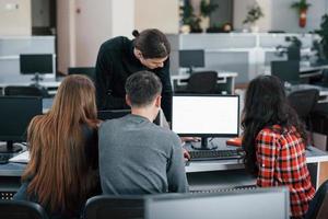 Screen with white color. Put your text there. Group of young people in casual clothes working in the modern office photo