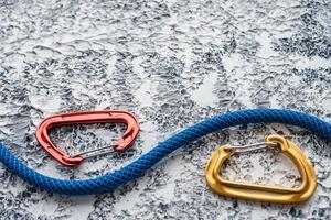 For sale. Isolated photo of climbing equipment. Part of carabiner lying on the white and grey colored table