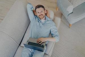 Happy young freelancer relaxing after finishing commission photo