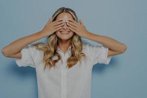 Blonde girl covering her eyes with hands photo