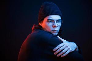 Thinking about some problems. Studio shot in dark studio with neon light. Portrait of serious man photo