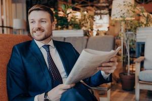 Portrait of successful young entrepreneur in formal suit sitting in cafe photo