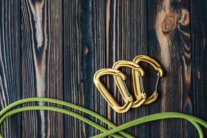 Ready for use. Isolated photo of climbing equipment. Parts of carabiners lying on the wooden table