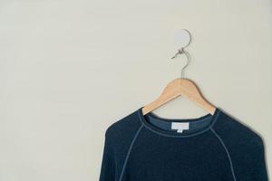 navy sweater hanging with wood hanger photo