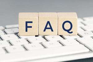 FAQ word on wooden block on computer keyboard. Frequently asked question concept photo
