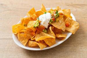 nachos chips de tortilla con jalapeño, guacamole, salsa de tomates y dip foto