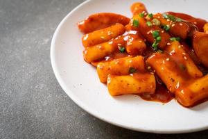 Korean rice cake stick with sausage in spicy sauce - Tteokbokki photo