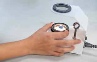 The Gemologist expertise in her laboratory fix the value of precious stone of the polariscope. photo