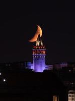 Moonset over Galata Tower in Istanbul, Turkey photo