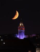 puesta de la luna sobre la torre de galata en estambul, turquía foto