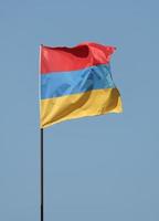 bandera armenia ondeando en asta de bandera foto
