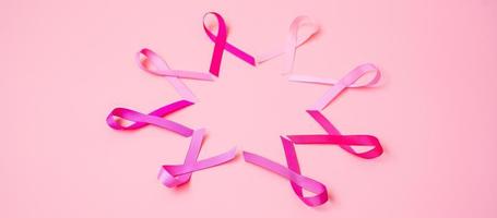 octubre mes de concientización sobre el cáncer de mama, cinta rosa sobre fondo rosa para apoyar a las personas que viven y están enfermas. concepto del día internacional de la mujer, la madre y el día mundial del cáncer foto