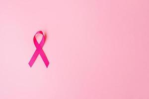 octubre mes de concientización sobre el cáncer de mama, cinta rosa sobre fondo rosa para apoyar a las personas que viven y están enfermas. concepto del día internacional de la mujer, la madre y el día mundial del cáncer foto