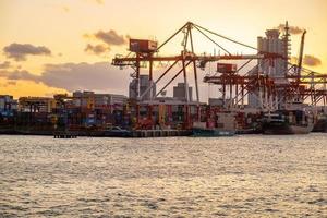 working crane and container Cargo ship of Logistics and transportation industry in Osaka city. Osaka, Kansai, Japan, 28 November 2019 photo