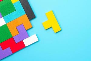 colorful wood puzzle pieces on blue background, geometric shape block. Concepts of logical thinking, Conundrum, solutions, rational, strategy, world logic day and Education photo