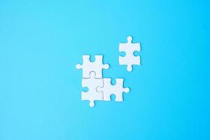 Group of white puzzle jigsaw pieces on blue background. Concept of solutions, mission, success, goals, cooperation, partnership, strategy and puzzle day photo