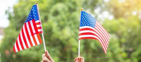 hand holding United States of America flag on green background. USA holiday of Veterans, Memorial, Independence  and Labor Day concept photo