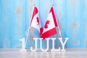 calendario de madera del 1 de julio con banderas de canadá en miniatura. canadá, día, y, feliz, celebración, conceptos foto