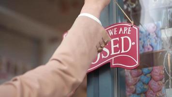 A woman turning over the shop sign video