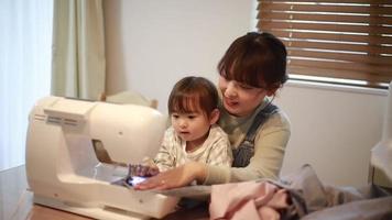 Parents and children using a sewing machine video