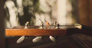 The technician worker figure fixing old guitar strings. photo