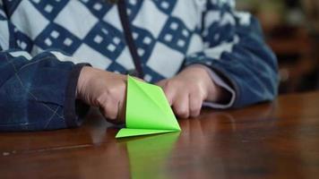 eine Frau, die einen Kranich mit Origami faltet video