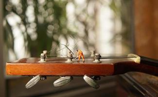 la figura del trabajador técnico arreglando viejas cuerdas de guitarra. foto