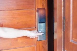 man holding handle of smart digital door lock while open or close the door. Technology, electrical and lifestyle concepts photo