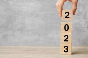 hand holding block 2023 text on table. Resolution, strategy, plan, goal, motivation, reboot, business and New Year holiday concepts photo