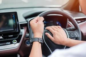 hombre conductor tocando la bocina de un automóvil durante la conducción en la carretera de tráfico, controlando a mano el volante en el vehículo. conceptos de transporte de viaje, viaje y seguridad foto