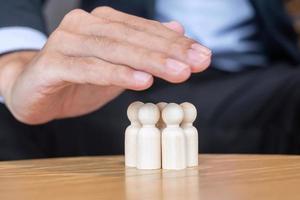 Businessman hand cover man wooden from crowd of employees. People, Business, Human resource management, Life Insurance, Teamwork and leadership Concepts photo